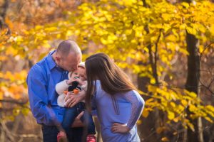 Parents kissing their daughter.